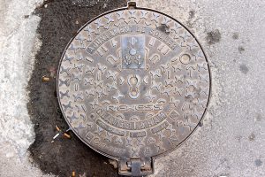 Image of a manhole cover in need of proper repair